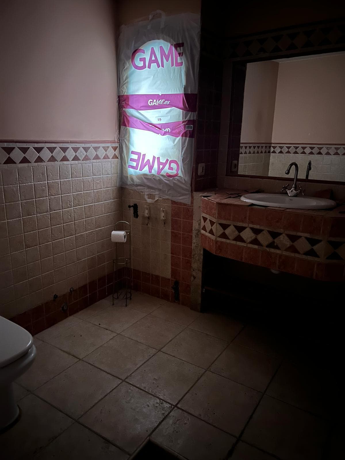 Baño antes de la reforma, con revestimientos antiguos y sanitarios originales