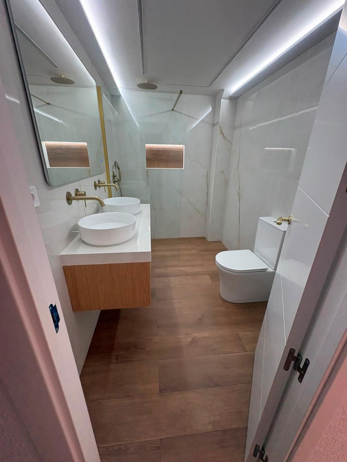 Baño reformado con sanitarios y mobiliario de líneas limpias