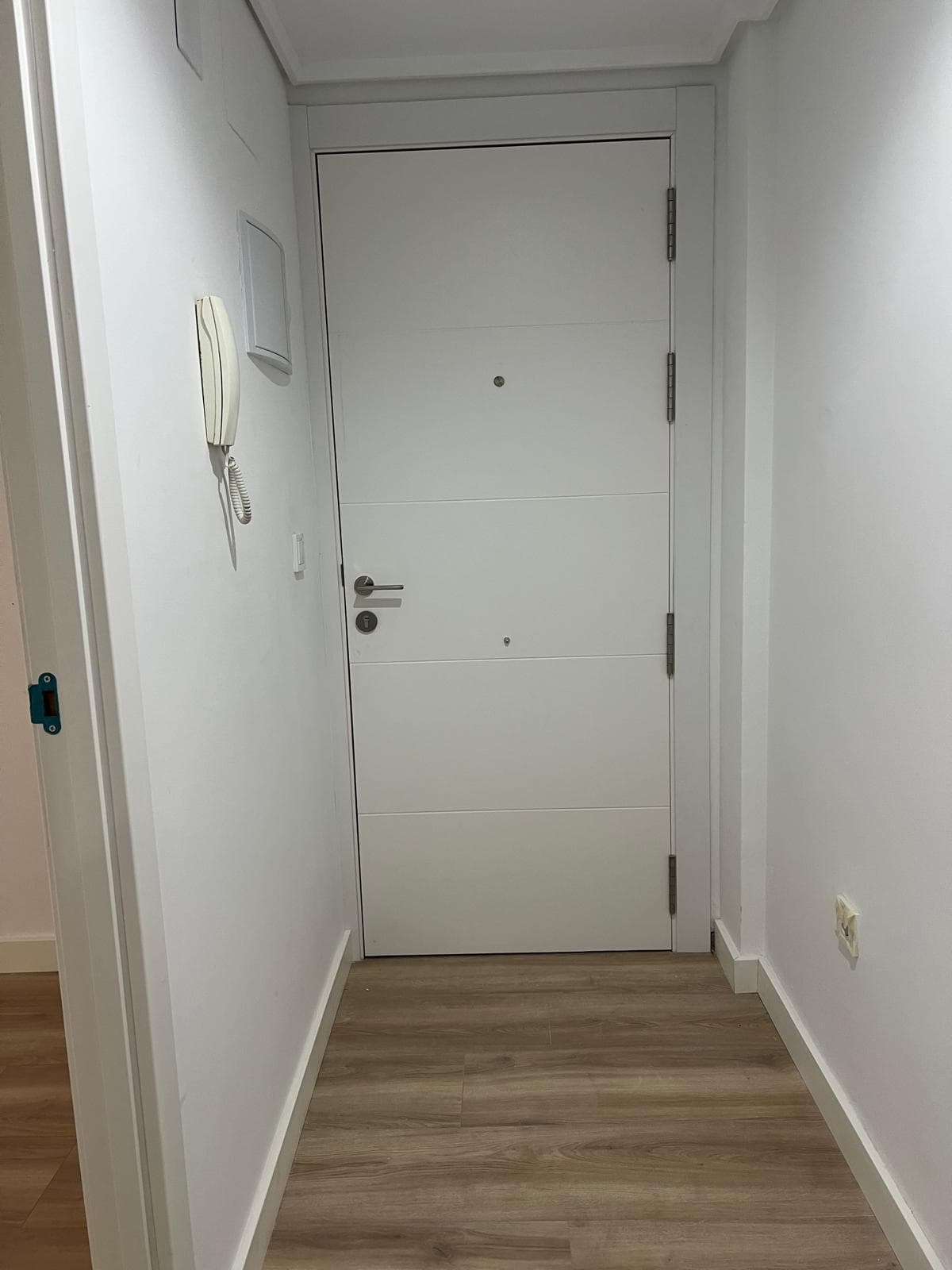Puerta de entrada de una vivienda reformada, abierta a un nuevo proyecto